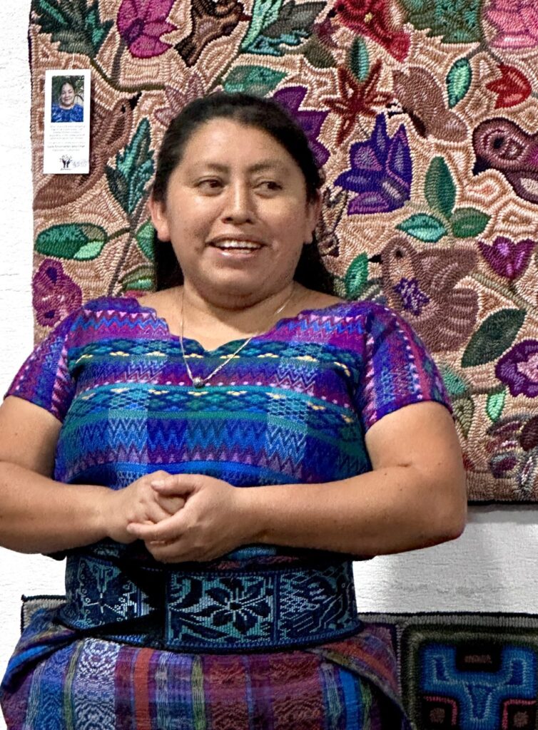 A maker holding her rug-hooked textile